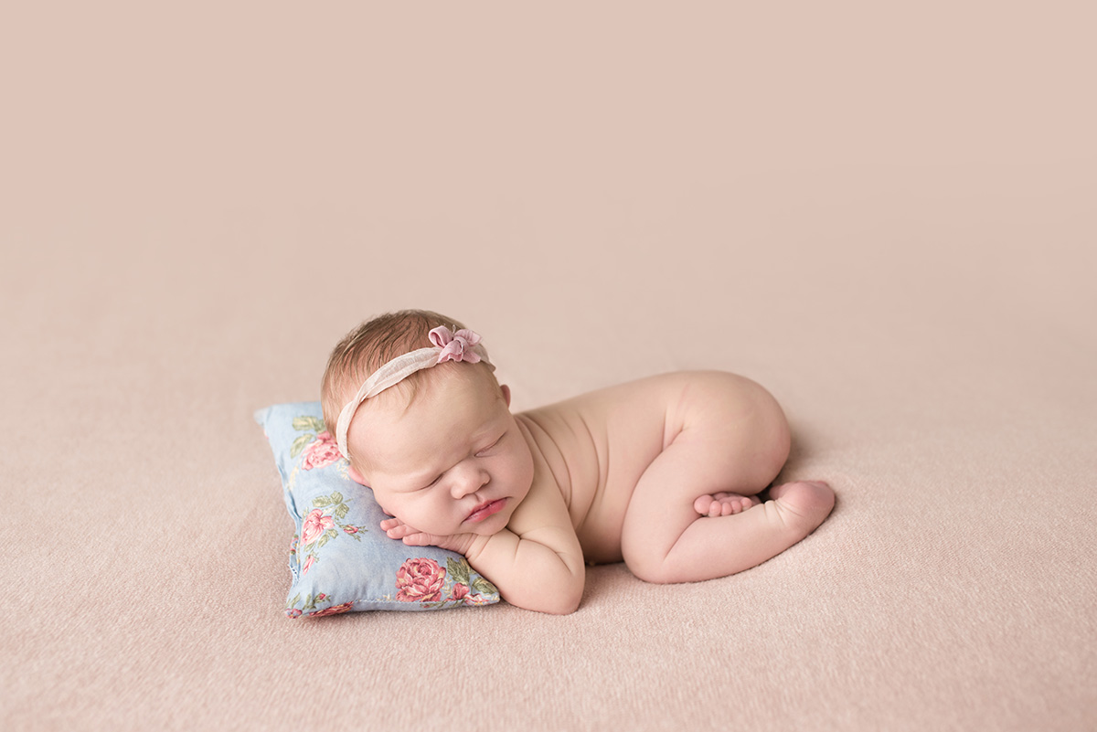 newborn girl sleeping on pillow