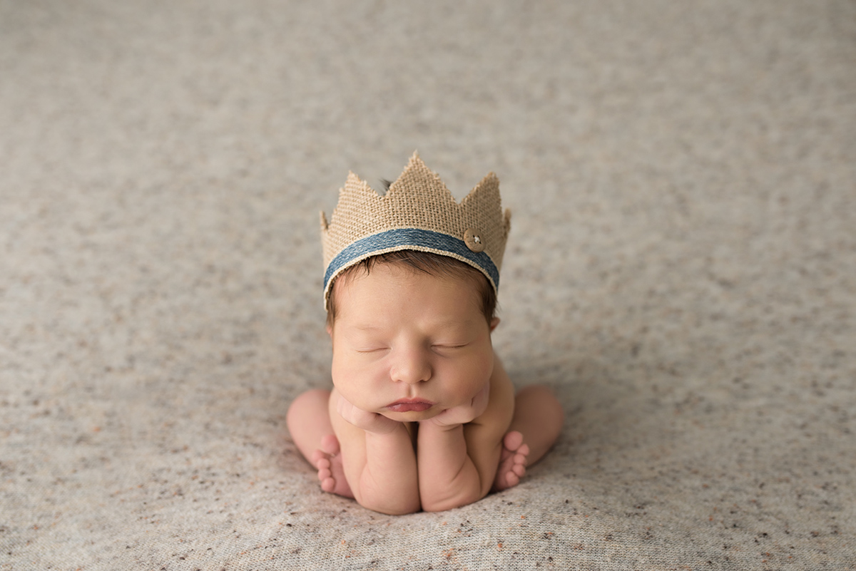 baby boy in froggy pose wearing a crown