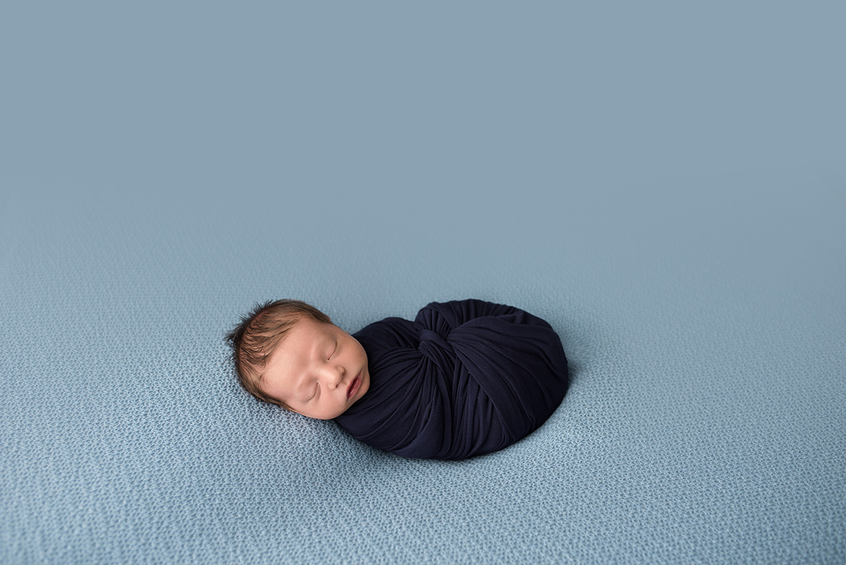 newborn boy wrapped in swaddle