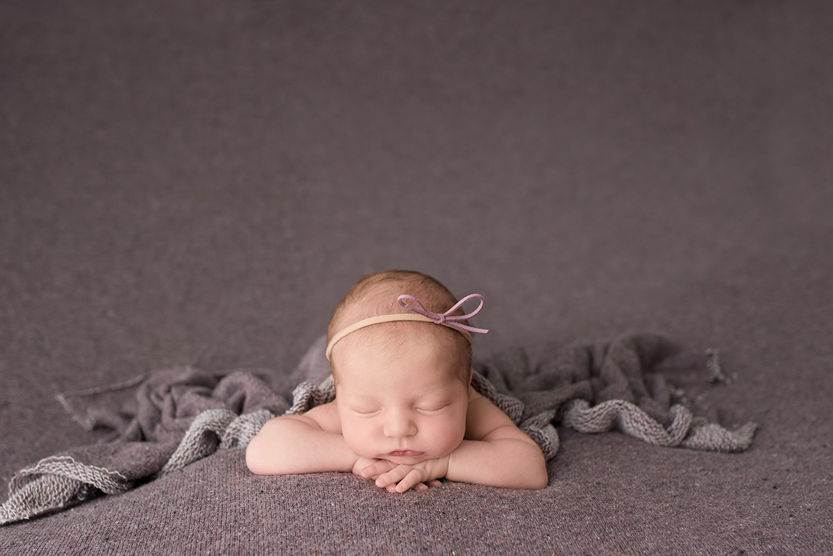 newborn sleeping on purple blanket
