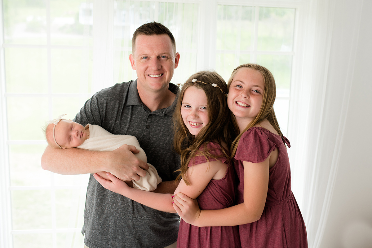 Dad with newborn and daughters
