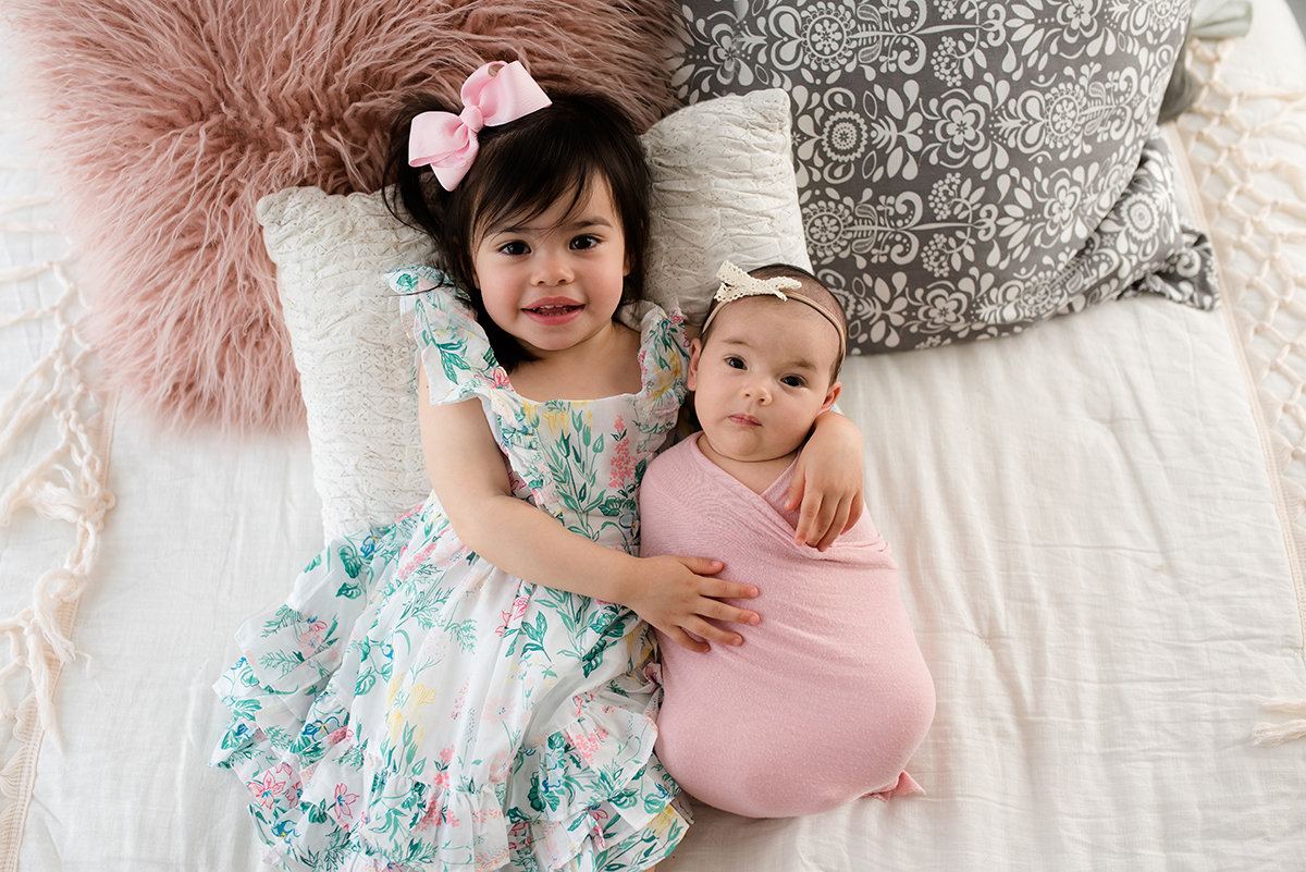 sibling with newborn in photo studio