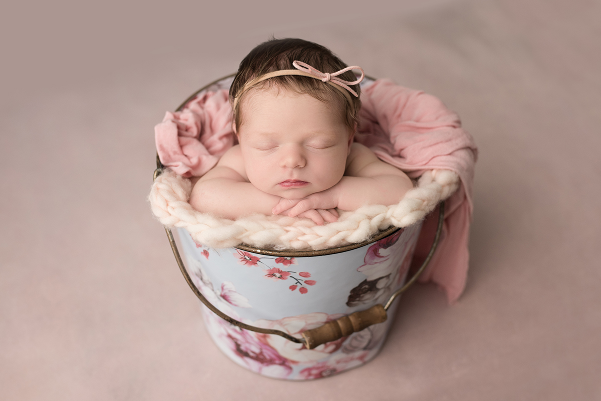 newborn in prop bucket