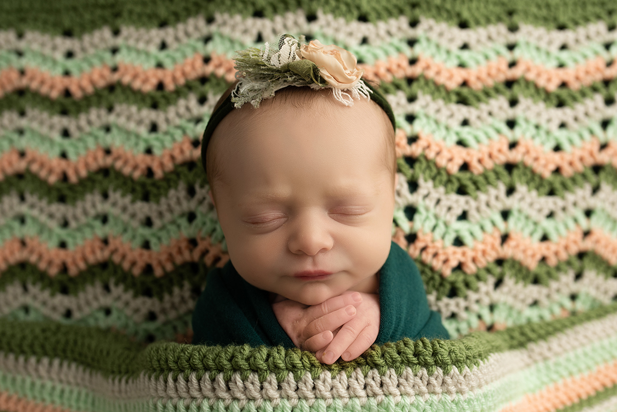 newborn in heirloom blanket during newborn photo session